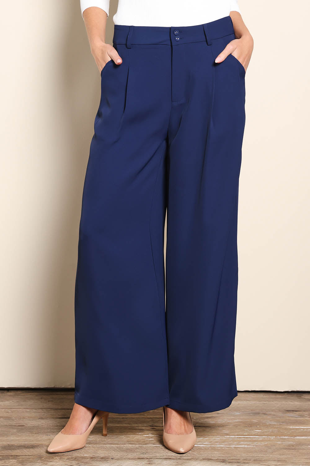 Model Madelinec wearing size 10 of the The Soft Suiting Pant – Navy in colour Navy, in a cropped view