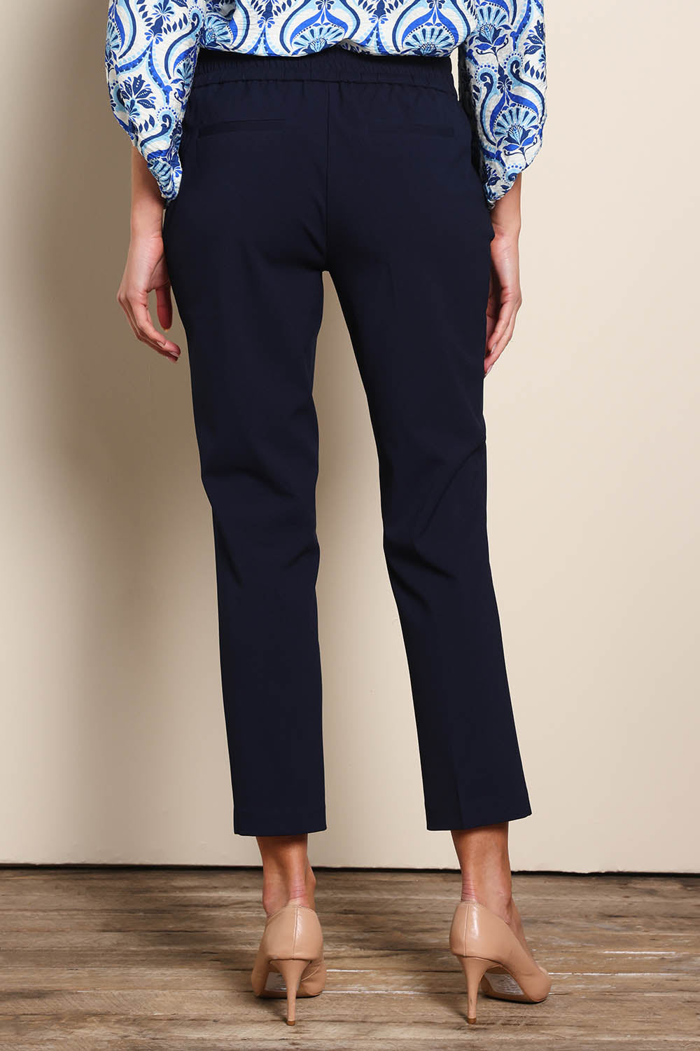 Model Madelinec wearing size 10 of the The Tapered Pull On Stretch Pant – Navy in colour Navy, from the back