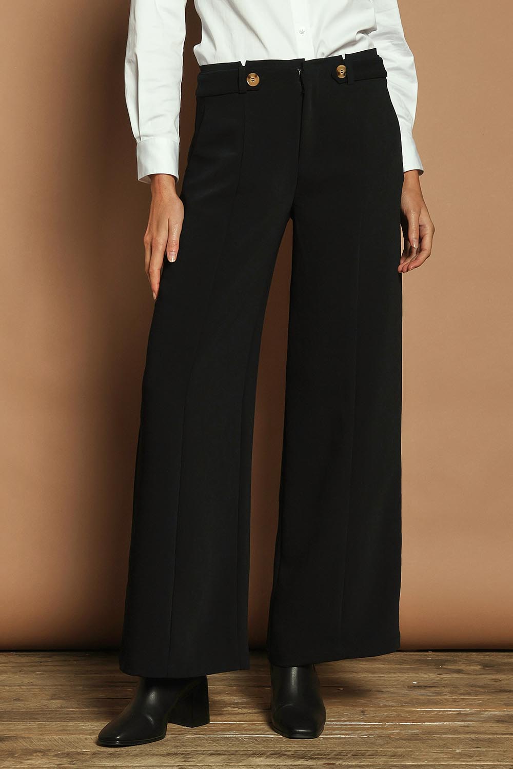 Model Madeline wearing size 10 of The Tab Detail Tailored Pant in colour Black (Black), from the front, cropped image