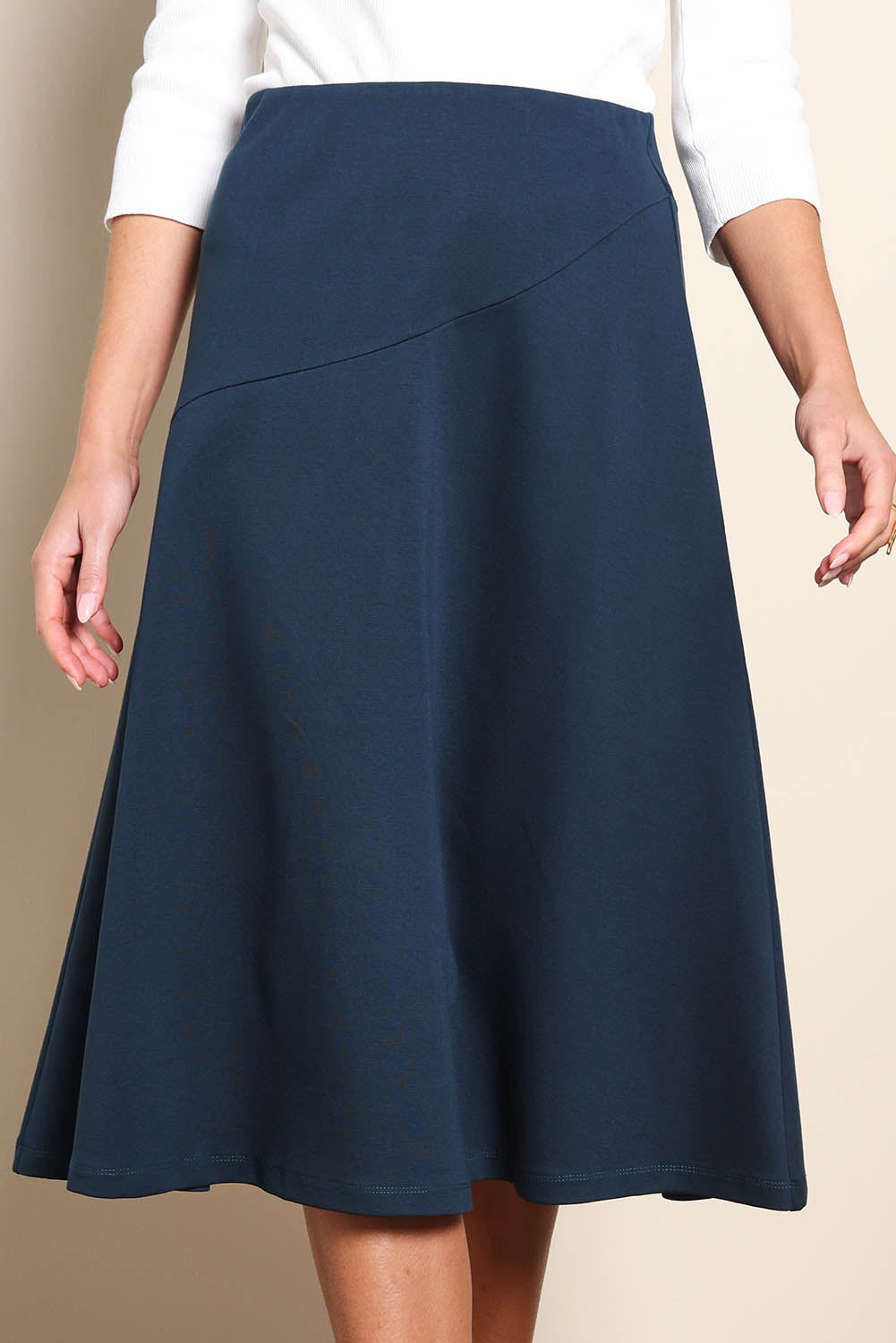 Model Madelinec wearing size 10 of the The Ponte Curve Seam Pull On Skirt – Lagoon in colour Lagoon, in a cropped view