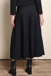 Model Madelinec wearing size 10 of the The Luxe Pleated Skirt – Black in colour Black, from the back