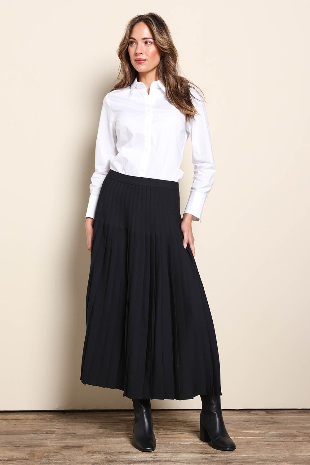 Model Madelinec wearing size 10 of the The Luxe Pleated Skirt – Black in colour Black, from the front