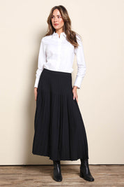 Model Madelinec wearing size 10 of the The Luxe Pleated Skirt – Black in colour Black, from the front