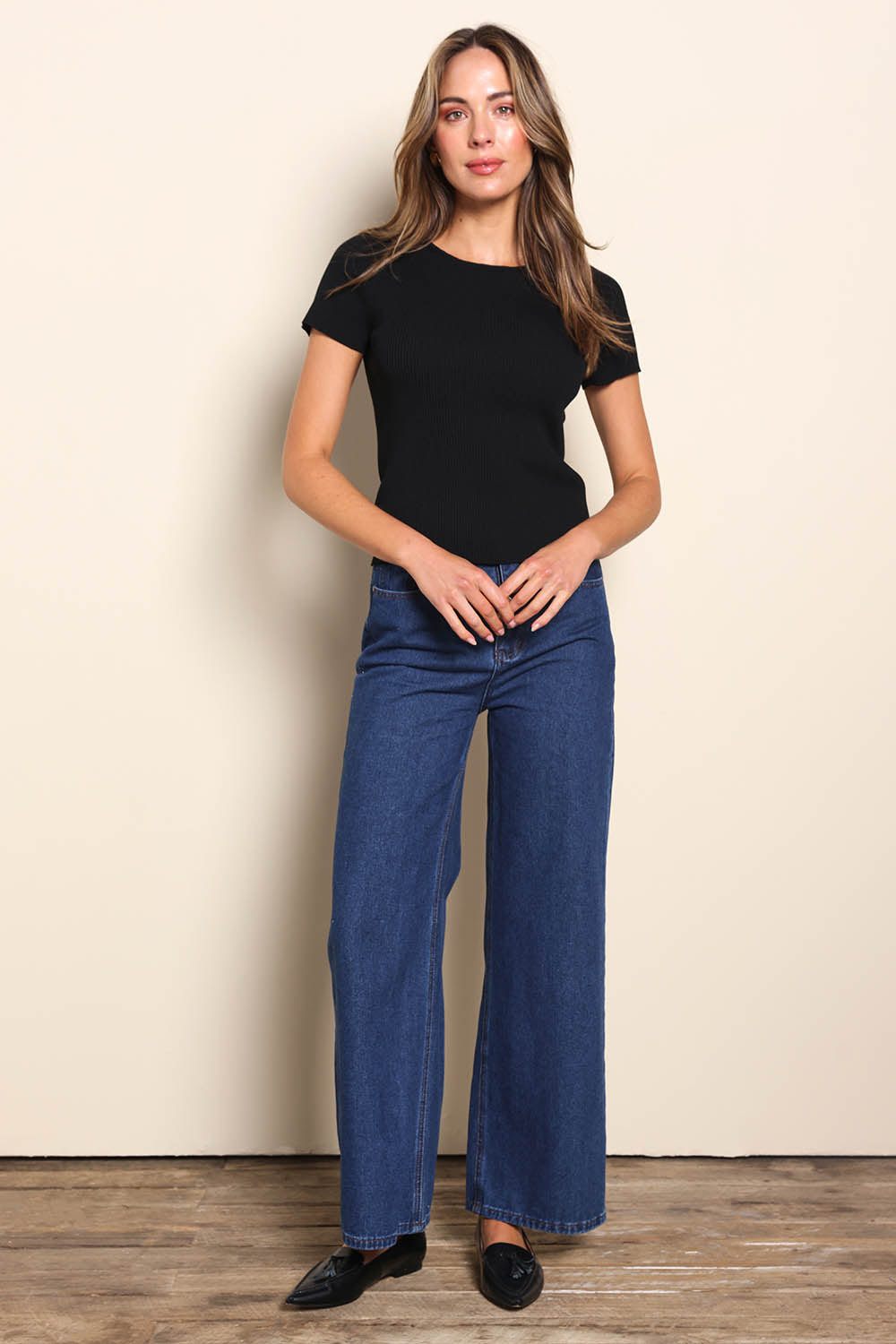 Model Madelinec wearing size 10 of the The Reversible Rib Knit Top – Black in colour Black, from the front