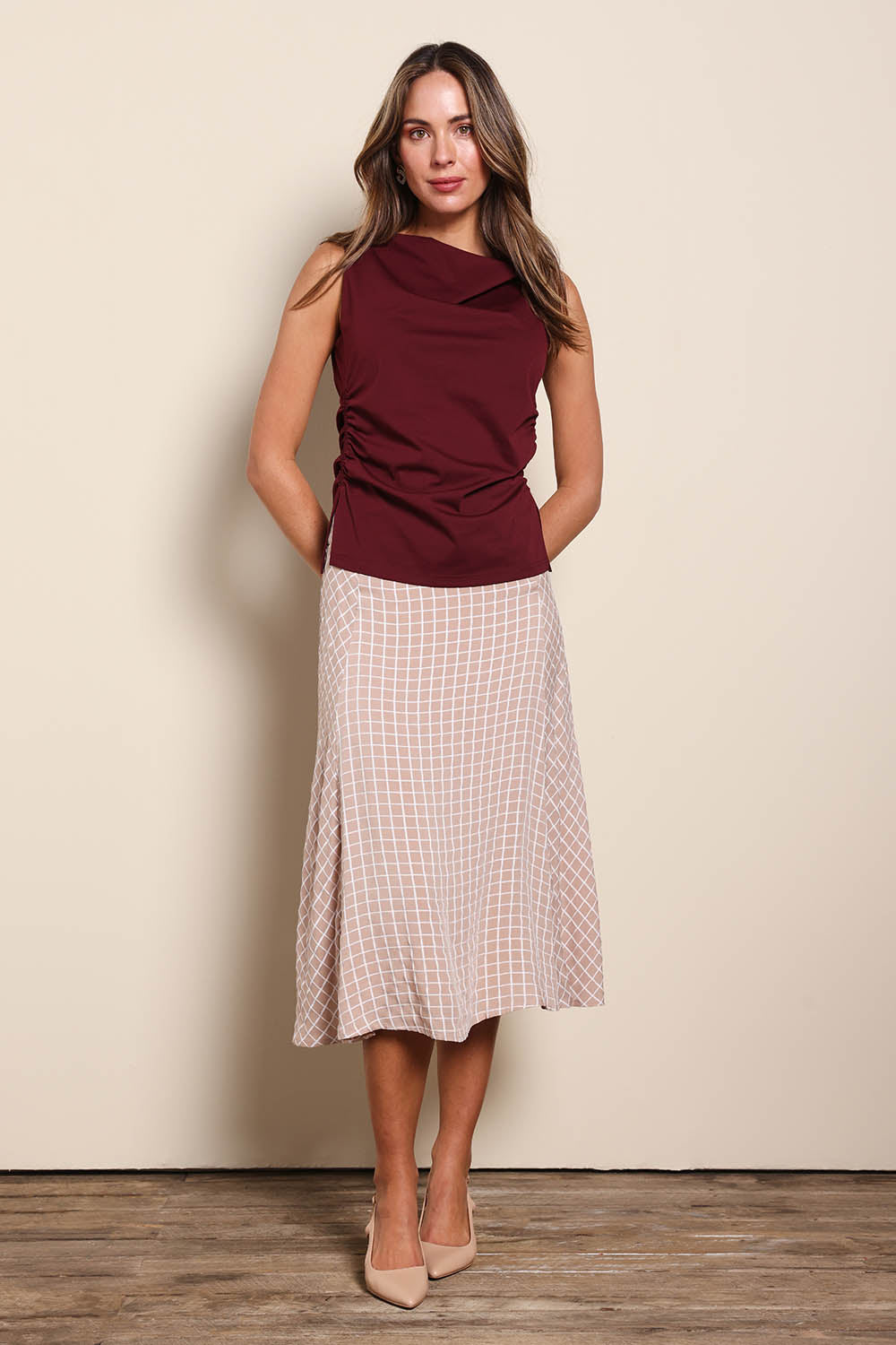 Model Madelinec wearing size 10 of the The Bias Panel Check Skirt - Sand in colour Sand, from the front