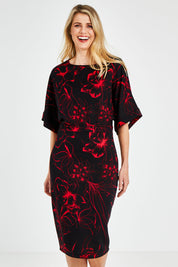 Model Kelly wearing size 10 of The Printed Kimono Sleeve Pencil Dress in colour Redfleur (Black), from the front, cropped image