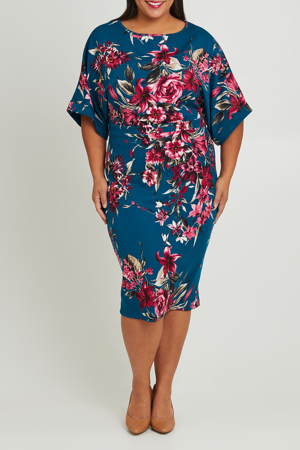 Model Ashleigh wearing size 16 of The Printed Kimono Sleeve Pencil Dress in colour Tealtropic (Blue), from the front, cropped image