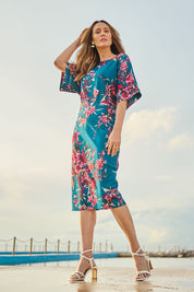 Model Clementine wearing size 10 of The Printed Kimono Sleeve Pencil Dress in colour Tealtropic (Blue), from the front, showing the whole outfit
