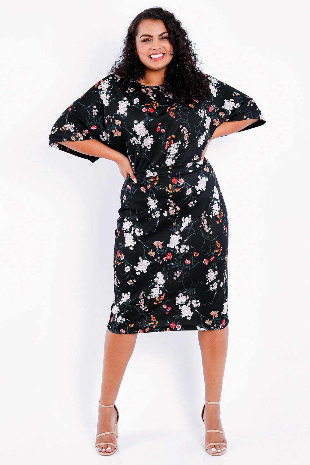 Model Sasha-Lee wearing size 16 of The Printed Kimono Sleeve Pencil Dress in colour Garden (Black), from the front, showing the whole outfit