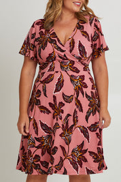 Model Fiona wearing size 16 of The Printed Jersey Faux Wrap Dress in colour Pinkfleur (Pink), from the front, cropped image