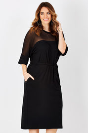 Model Laura wearing size 12 of the Belle Mesh Yoke Dress in colour Back (Black), from the front, cropped image