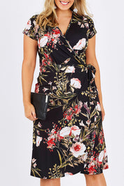 Model Jess wearing size 12 of the Belle Orange Blossom Wrap Dress in colour BlosPrint, from the front, cropped image