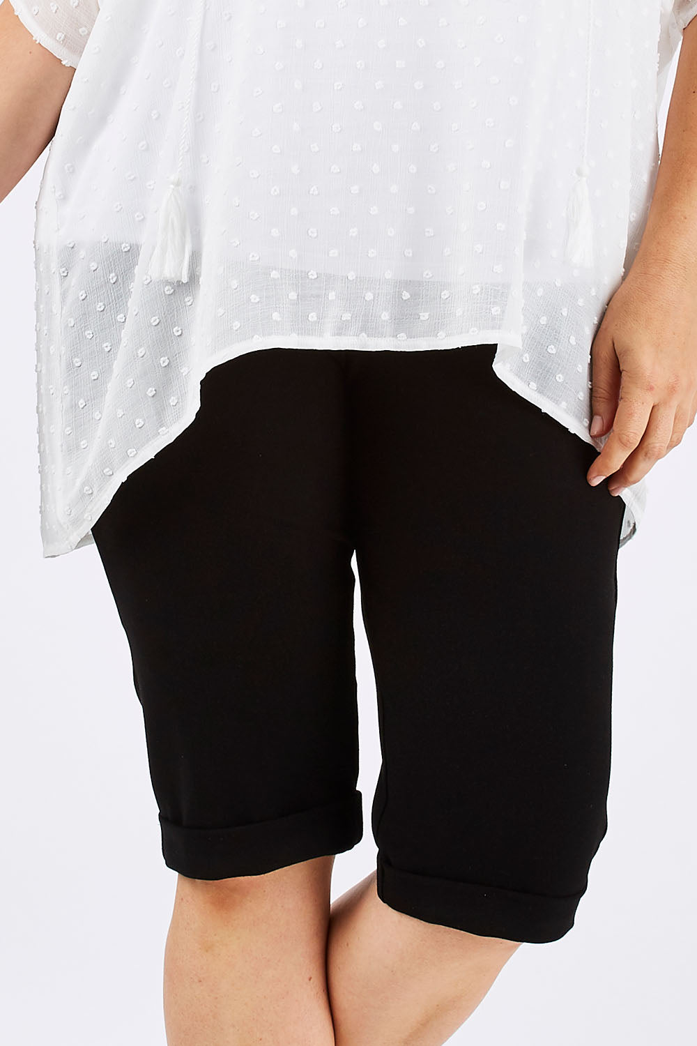 Model Ljubenka wearing size 16 of the Belle Knee Short in colour Black (Black), from the front, cropped image