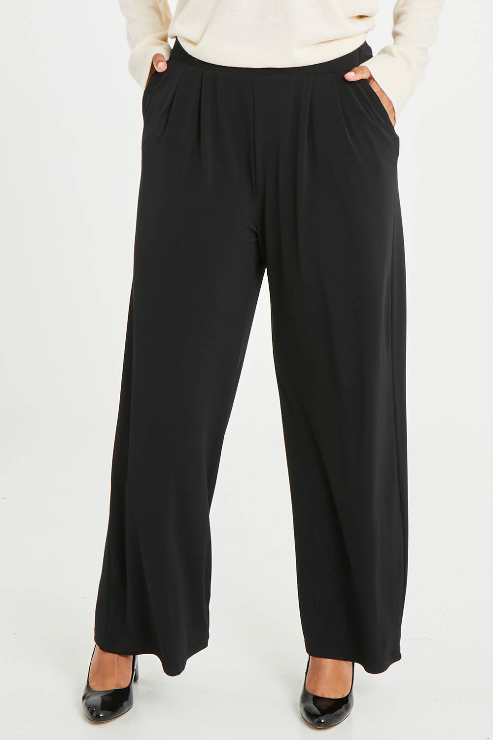 Model Noli wearing size 14 of the Belle Wide Leg Pant in colour Black (Black), from the front, cropped image