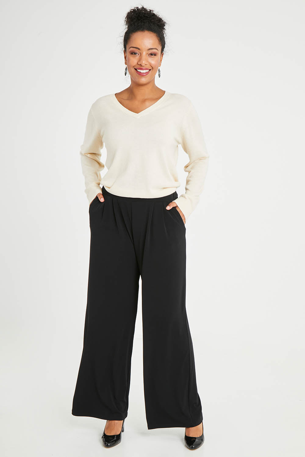 Model Noli wearing size 14 of the Belle Wide Leg Pant in colour Black (Black), from the front, showing the whole outfit
