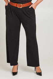 Model Poppy wearing size 16 of the Belle Wide Leg Pant in colour Black (Black), from the front, cropped image