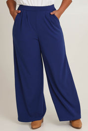 Model Ashleigh wearing size 16 of the Belle Wide Leg Pant in colour Frenchnavy (Blue), from the front, cropped image