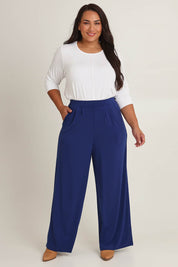 Model Ashleigh wearing size 16 of the Belle Wide Leg Pant in colour Frenchnavy (Blue), from the front, cropped image