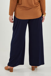 Model Maddy wearing size 16 of the Belle Wide Leg Pant in colour Navy (Blue), from the back