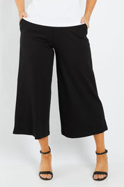 Model Laura wearing size 12 of the Belle Palazzo Ponte Crop in colour Black (Black), from the front, cropped image