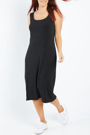 Model Laura wearing size 12 of the Belle Basic Slip Dress in colour Black (Black), from the front, cropped image