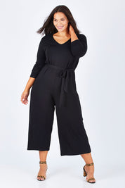 Model Lauren wearing size 16 of the Belle 7/8 Sleeve Knit Jumpsuit With Self Belt in colour Black (Black), from the front, showing the whole outfit