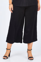 Model Jess wearing size 12 of the Belle Dress Pant in colour Black (Black), from the front, cropped image