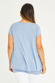 Model Palatina wearing size 16 of the Belle New Cap Sleeve Forgiver Tee in colour Chambray (Blue), from the back