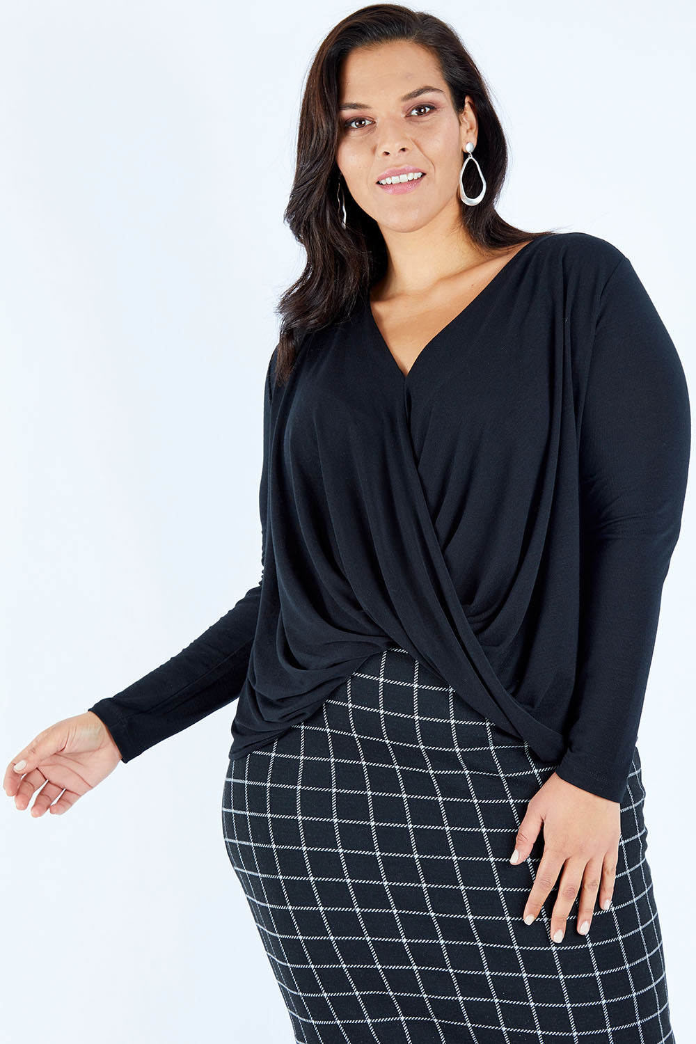Model Lauren wearing size 16 of the Belle High Low Knit in colour Black (Black), from the front, cropped image