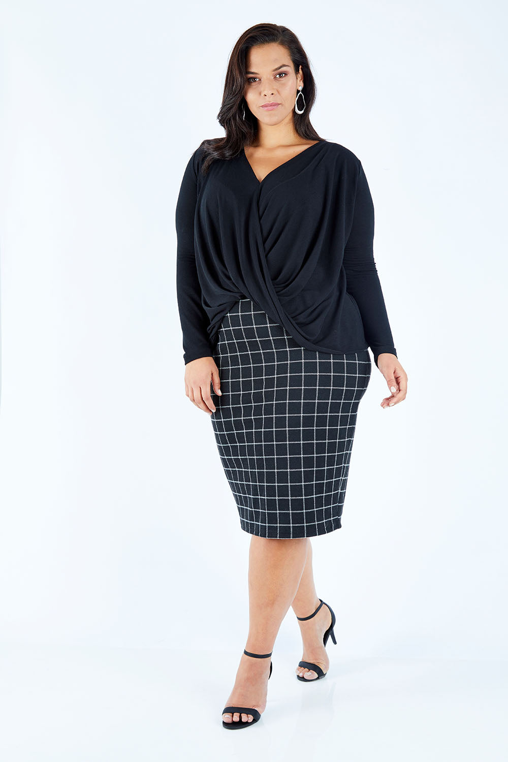 Model Lauren wearing size 16 of the Belle High Low Knit in colour Black (Black), from the front, showing the whole outfit
