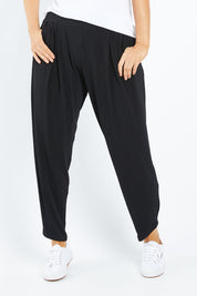 Model Laura wearing size 12 of the Belle Taper Pant in colour Black (Black), from the front, cropped image