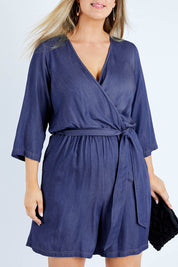 Model Jess wearing size 14 of the Belle Tencel Playsuit in colour Denim (Blue), from the front, cropped image