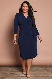 Model Ashleigh wearing size 16 of the Belle Basic Wrap Dress in colour Navy (Blue), from the front, showing the whole outfit