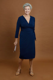 Model Elise wearing size 10 of the Belle Basic Wrap Dress in colour Navy (Blue), from the front, showing the whole outfit