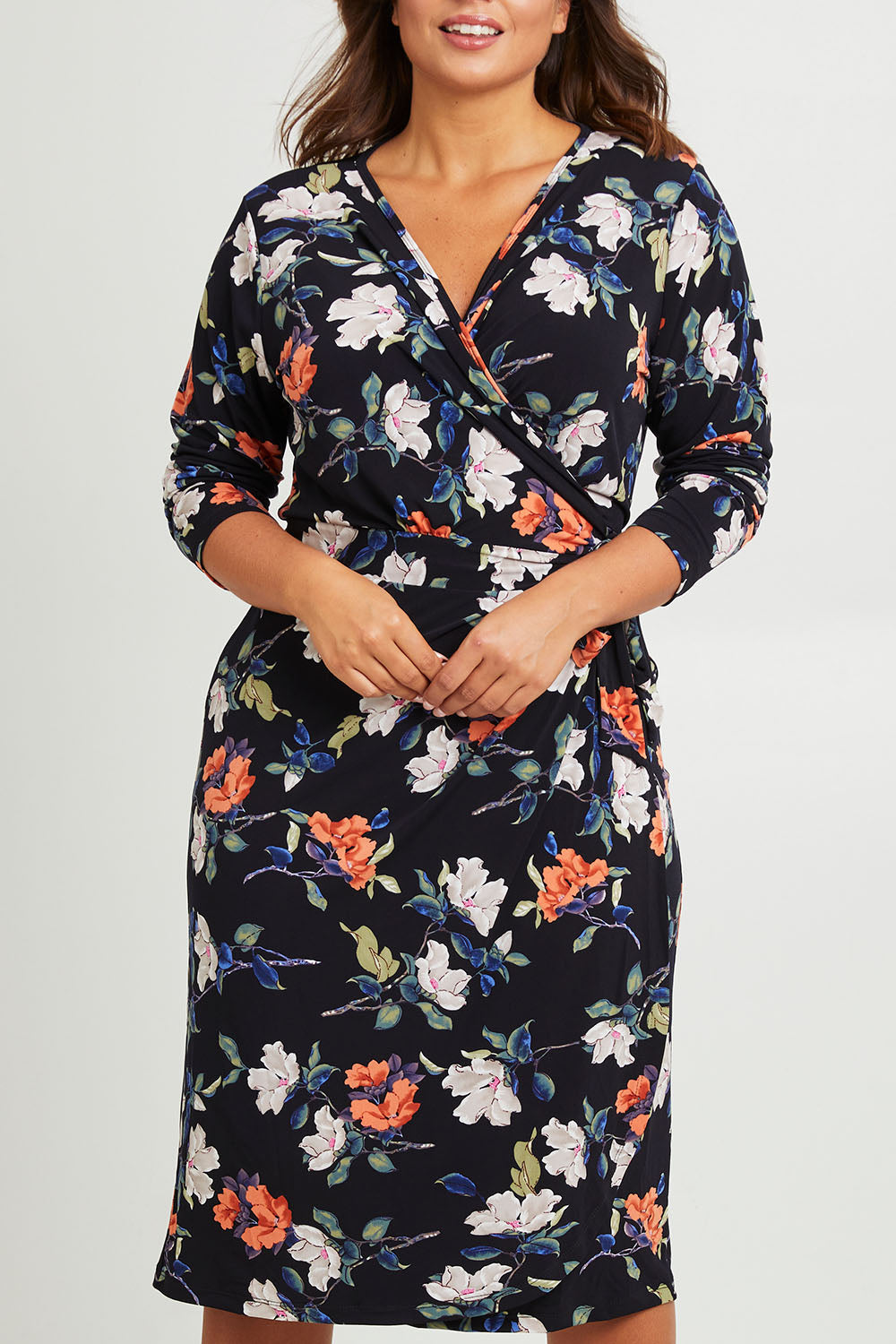 Model Monique wearing size 14 of the Belle Heather Floral Wrap Dress in colour Florals (Blue), from the front, cropped image