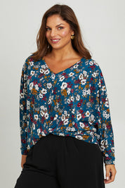 Model Monique wearing size 14 of the Belle Hip Knot Printed Tee in colour Tealfleur (Green), from the front, cropped image