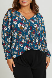 Model Monique wearing size 14 of the Belle Hip Knot Printed Tee in colour Tealfleur (Green), from the front, cropped image