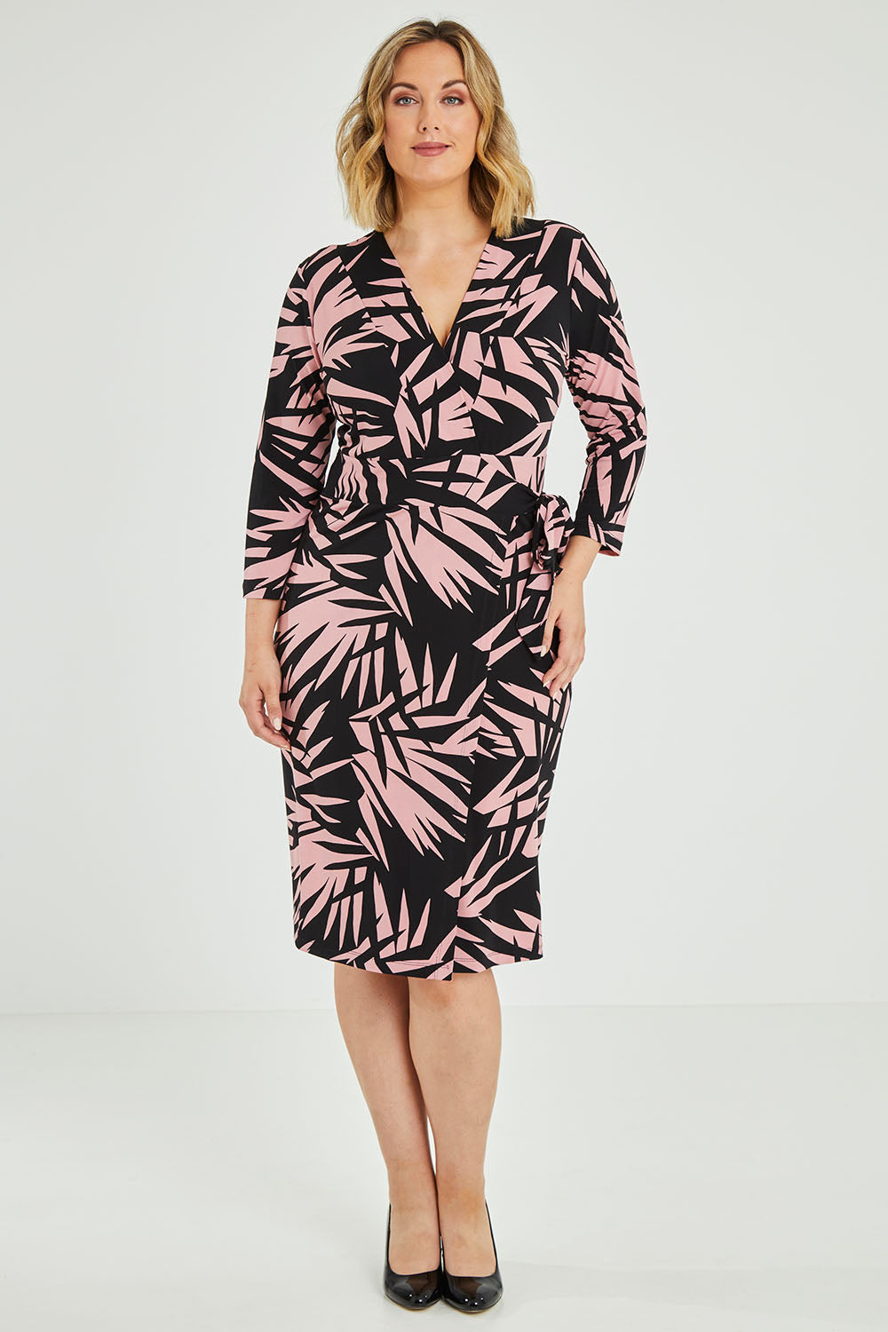 Model Jess wearing size 12 of the Belle Jungle Print Wrap Dress in colour Jungle (Black), from the front, showing the whole outfit