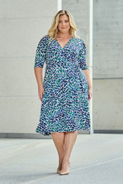 Model Caitlin wearing size 18 of the Belle X Over Full Skirt Dress in colour Bluegreen (Blue), from the front, showing the whole outfit