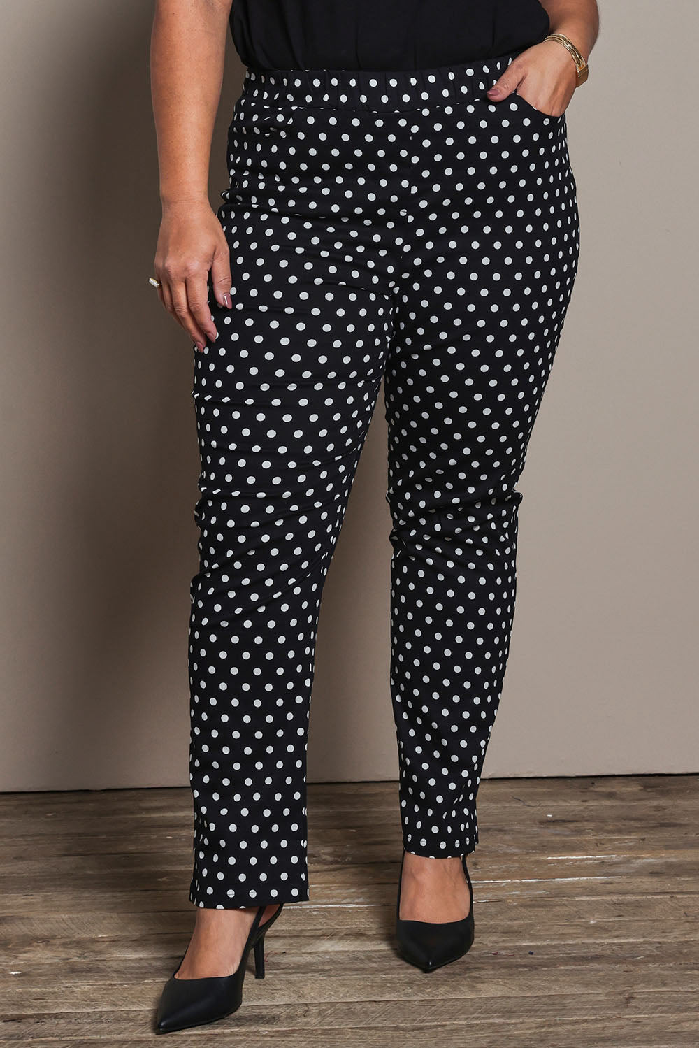 Model Ashleigh wearing size 16 of the Belle Printed Pull On Slim Leg Cotton Stretch  Pant in colour Blackwhite (Black), from the front, cropped image