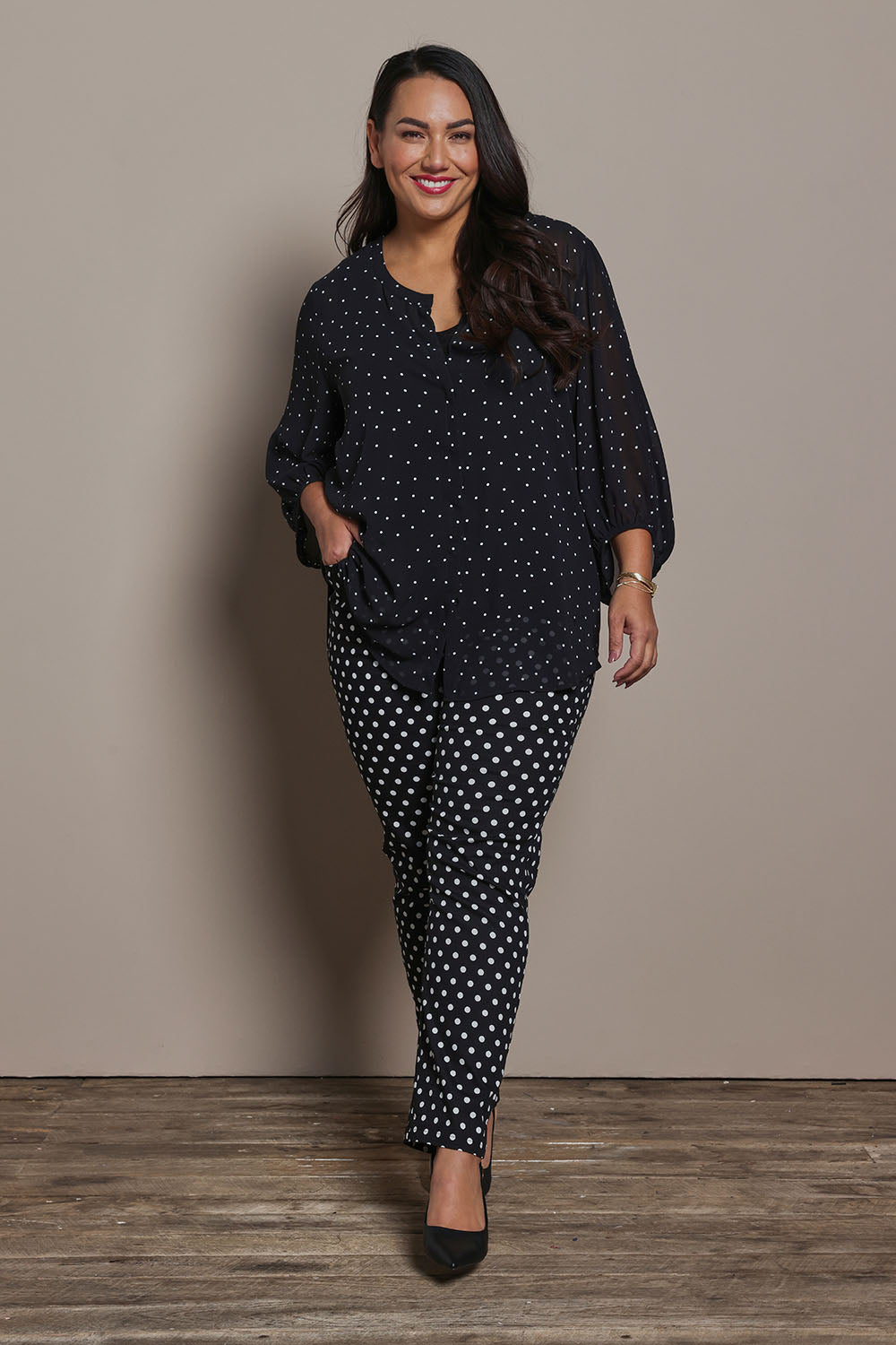 Model Ashleigh wearing size 16 of the Belle Printed Pull On Slim Leg Cotton Stretch  Pant in colour Blackwhite (Black), from the front, showing the whole outfit