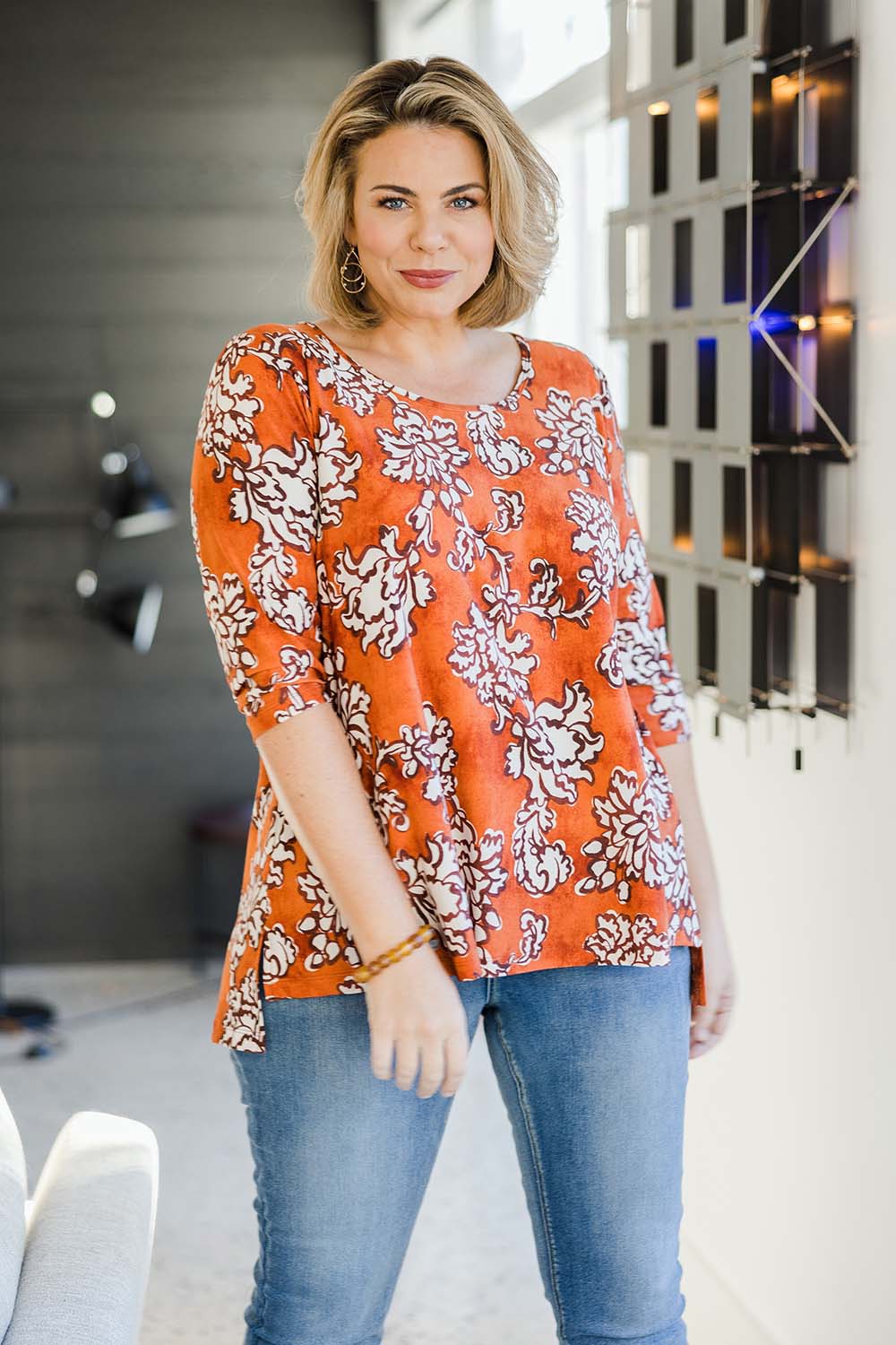 Model Fiona wearing size 10 of the Belle High Low Tee Shirt in colour Rustfloral, from the front, showing the whole outfit