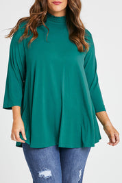 Model Laura wearing size 14 of the Belle Turtleneck Draped Bamboo Tee in colour Teal (Green), from the front, cropped image