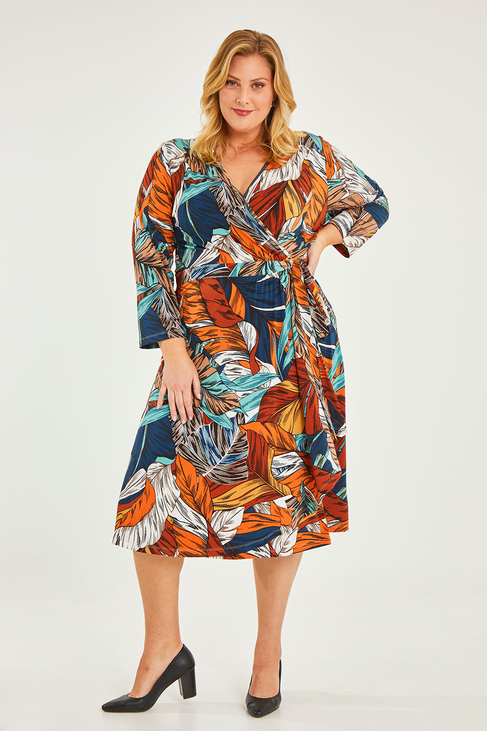 Model Caitlin wearing size 20 of the Belle Faux Long Sleeve Wrap Dress in colour Leafprint (White), from the front, showing the whole outfit