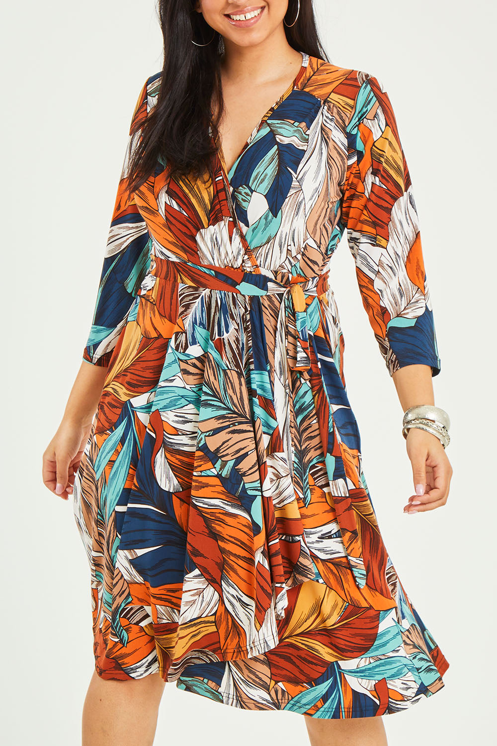 Model Terri-Leigh wearing size 14 of the Belle Faux Long Sleeve Wrap Dress in colour Leafprint (White), from the front, cropped image
