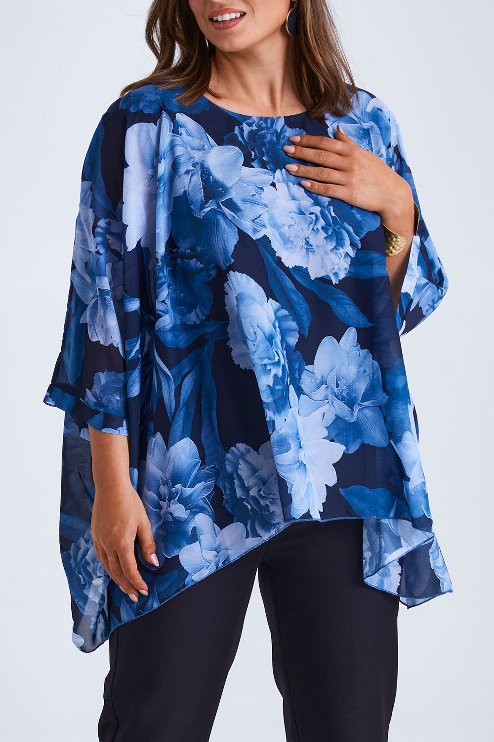 Model Monique wearing size 14 of the Belle Chiffon Overlay Top in colour Bluefloral (Blue), from the front, cropped image
