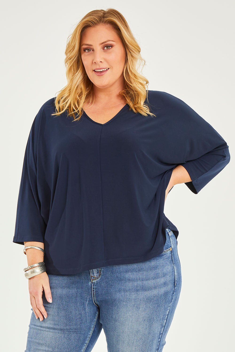 Model Caitlin wearing size 20 of the Belle Recycled Batwing Top in colour Navy (Blue), from the front, cropped image