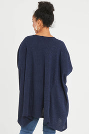 Model Noli wearing size 14 of the Belle Rib Knit Throw Over in colour Navymarle (Blue), from the back