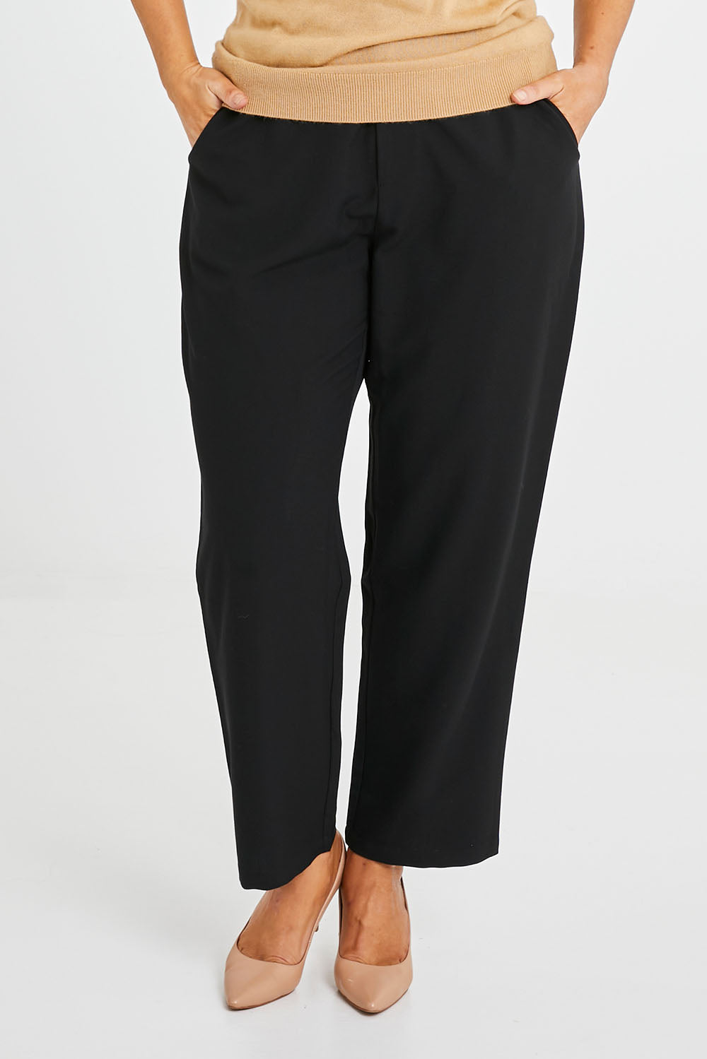 Model Laura wearing size 14 of the Belle Classic Tapered Pant in colour Black (Black), from the front, cropped image