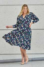 Model Caitlin wearing size 18 of the Belle Printed Faux Wrap Dress in colour Tealfleur (Green), from the front, showing the whole outfit
